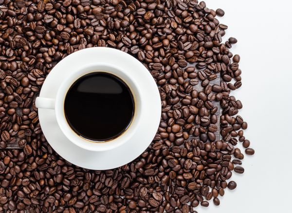 فنجان قهوه و دانه های قهوه با ناحیه سفید برای کپی sp