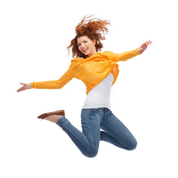 مفهوم شادی آزادی حرکت و مردم - زن جوان خندان در حال پریدن در هوا