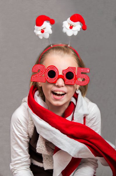 دختر بچه شاد در کریسمس نمادها و عینک 2015