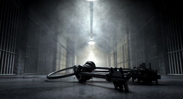 تصویر مفهومی از یک راهرو وهم‌آور در یک زندان در شب که سلول‌های زندان را نشان می‌دهد که با نورهای شوم مختلف نور ضعیفی دارند و دسته‌ای از کلیدهای سلول به طرز شومی روی زمین افتاده‌اند