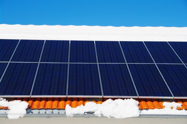 سلول های خورشیدی روی سقف زمستانی با برف 