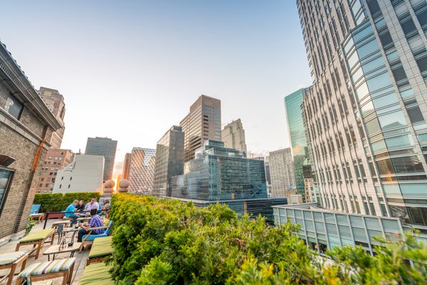 ساختمان ها و باغ بام در منهتن منظره شگفت انگیز غروب خورشید در شهر نیویورک