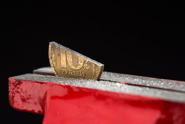 یک نیم سکه برش ده روبلی فشرده شده در ابزار گیره فلزی مفهوم تورم و بحران مالی در فدراسیون روسیه