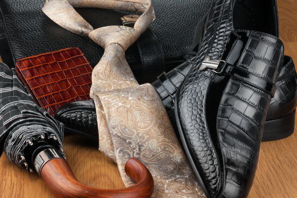 کفش های مردانه کلاسیک کراوات چتر کیف پول و کیف در کف چوبی می تواند به عنوان پس زمینه استفاده شود