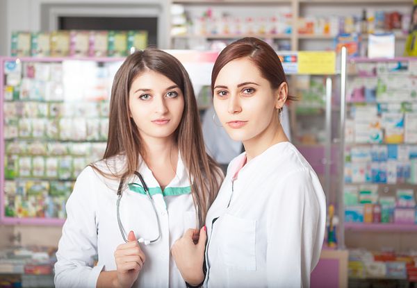 دو داروساز که مشتریان را در داروخانه بزرگ می کنند لبخند به دوربین کسب و کار مراقبت های بهداشتی سبک کسب و کار