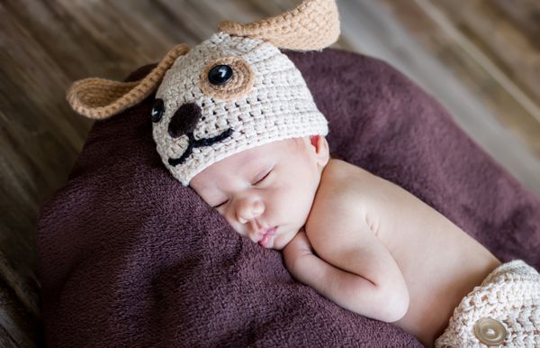 نوزاد ناز در کلاه بافتنی می خوابد