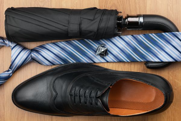 کفش های مردانه کلاسیک کراوات چتر دکمه سرآستین روی کف چوبی می توانند به عنوان پس زمینه استفاده شوند