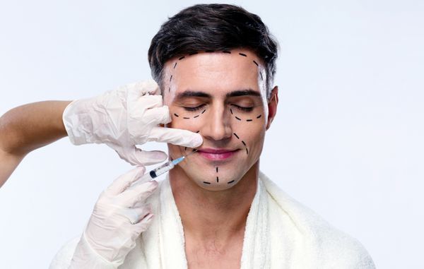مرد خوش تیپ با بسته در جراحی پلاستیک با سرنگ در ج