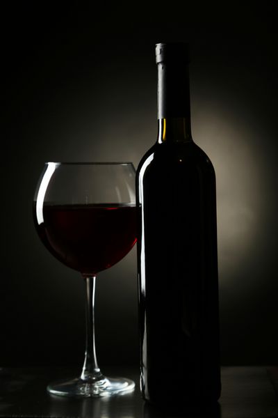 شیشه قرمز با بطری در پس زمینه سیاه