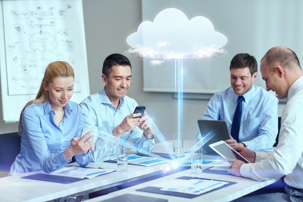 کسب و کار مردم محاسبات ابری و مفهوم فناوری - تیم تجاری خندان با گوشی های هوشمند رایانه های رایانه لوحی که در دفتر کار می کنند