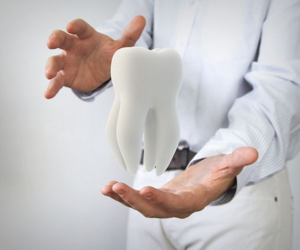مفهوم مراقبت از دندان دندان مولر در دستان مرد