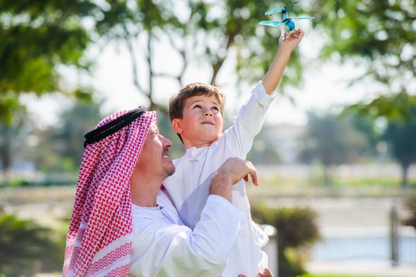 پدر و بچه عربی در فضای باز بازی می کنند