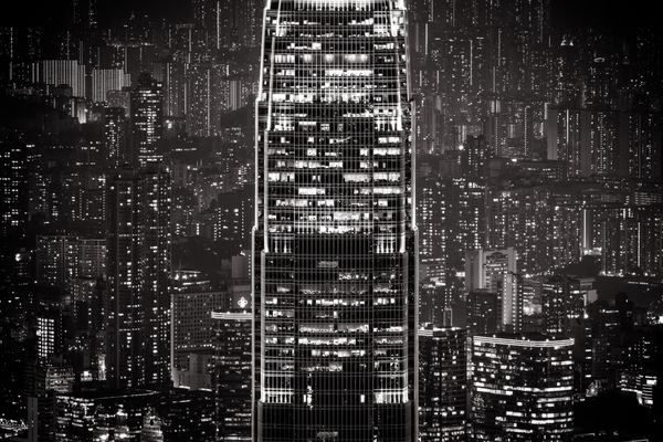 منظره شهری شبانه آینده‌نگر انتزاعی با آسمان‌خراش‌های نورانی پس‌زمینه سیاه و سفید هنگ‌کنگ