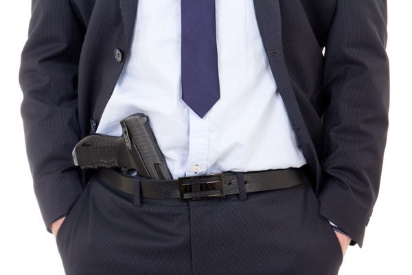 کارآگاه پلیس یا محافظ با اسلحه در شلوار جدا شده در زمینه سفید