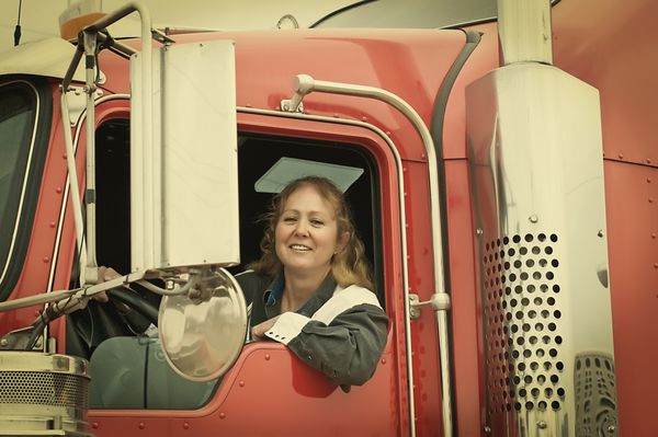 زن راننده کامیون که از شیشه سمت راننده به بیرون خم شده است ظاهر رترو اینستاگرام