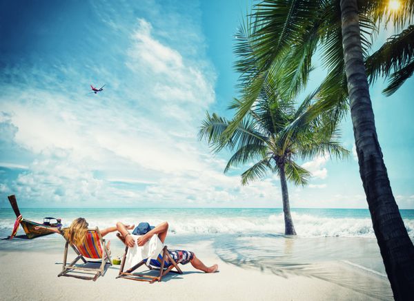 زن و شوهر در ساحل در تفرجگاه گرمسیری مفهوم مجله سفر