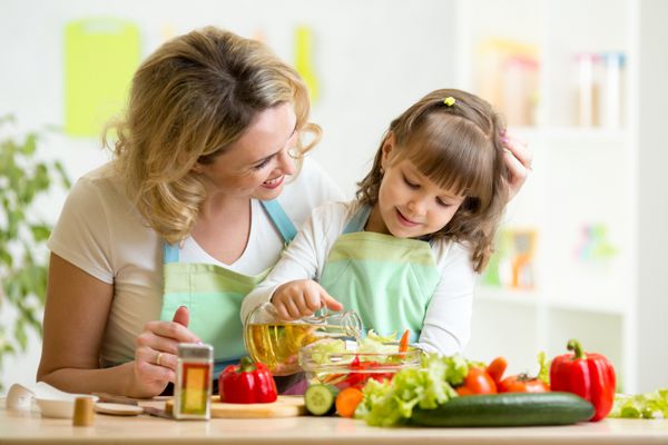 مادر و دختر بچه غذای سالم را در خانه تهیه می کنند