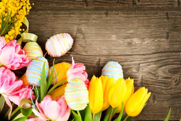 پس زمینه عید پاک قاب زیبای پس زمینه تعطیلات عید پاک با تخم مرغ های رنگارنگ و گل های لاله تزئین شده است فصل بهار