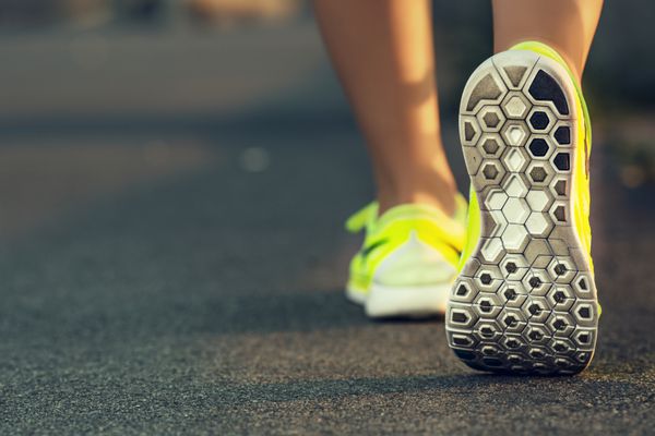 پاهای زن دونده در حال دویدن در نزدیکی جاده روی کفش مدل تناسب اندام زنانه تمرین دویدن طلوع آفتاب مفهوم سبک زندگی سالم ورزشی