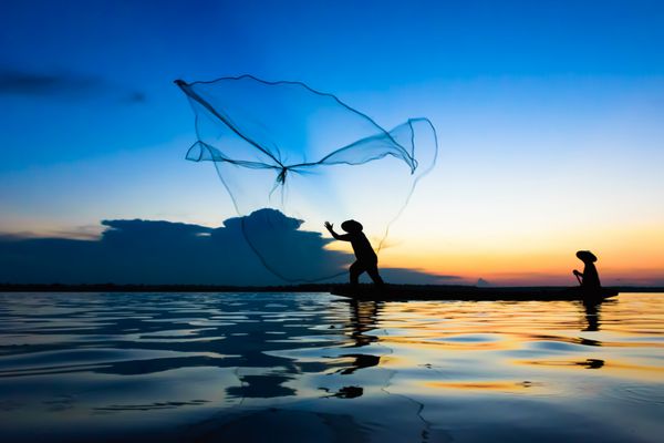 اقدام ماهیگیر هنگام ماهیگیری در هنگام غروب آفتاب