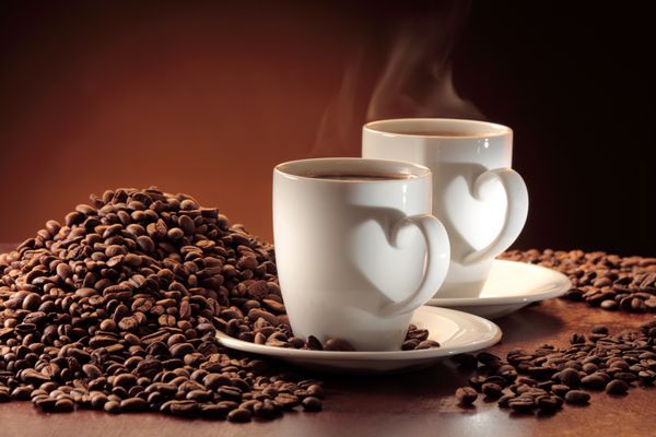 دو فنجان قهوه بخارپز و یک عدد دانه قهوه دو فنجان قهوه دسته ای شکل قلب