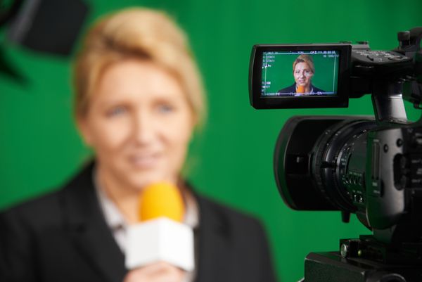 خبرنگار زن در حال ارائه گزارش در استودیوی تلویزیونی