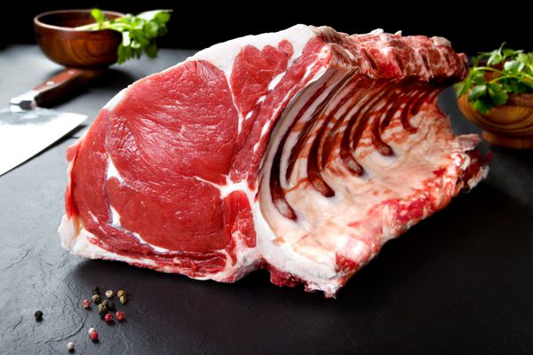 گوشت تازه و خام دنده و گوشت خوک روی تخته سیاه پس زمینه سیاه