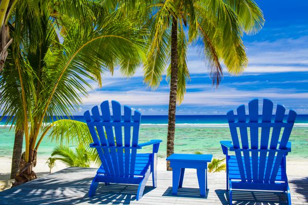 دو صندلی آبی در جلوی ساحل در ساحل شگفت انگیز جزایر آشپزی