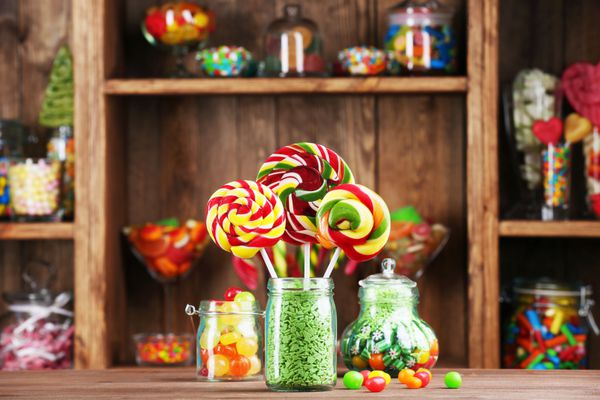 آب نبات های رنگارنگ در شیشه های روی میز در فروشگاه