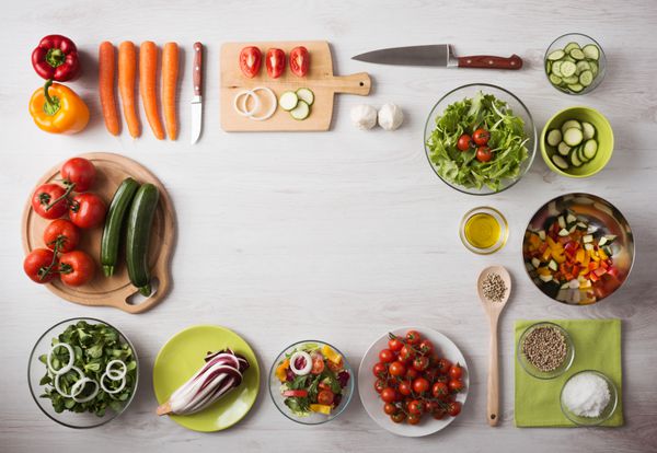 مفهوم تغذیه سالم با سبزیجات تازه و کاسه سالاد روی میز کار چوبی آشپزخانه کپی sp در مرکز نمای بالا