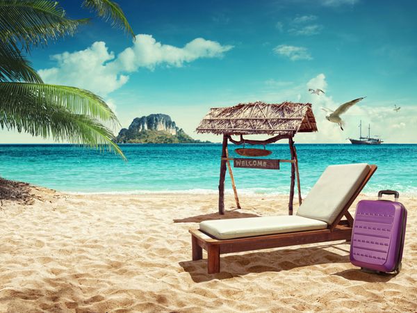 مسافرت رفتن صندلی و چمدان ساحلی در ساحل شنی مفهومی برای استراحت
