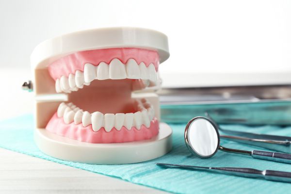 دندان‌های سفید و مواد دندانی روی پس‌زمینه میز