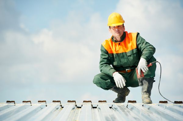 کارگر سازنده با مته دستی در نصب سقف پروفیل فلزی