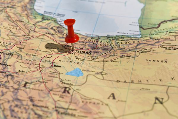 تهران بر روی نقشه با فشار دهنده قرمز مشخص شده است تمرکز گزینشی بر کلمه تهران و فشار پین زاویه دار است و سایه ای را به سمت چپ می اندازد