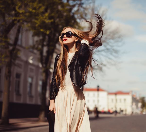 دختر بلوند زیبا با عینک آفتابی با لب های قرمز در خیابان و در موهای شما خورشید لباس خیابانی مد لباس