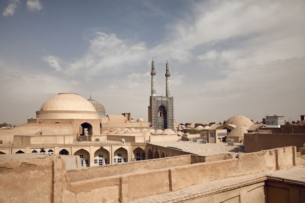 شهر تاریخی قدیمی یزد با بناهای سنتی خشت و آجر در افق آن