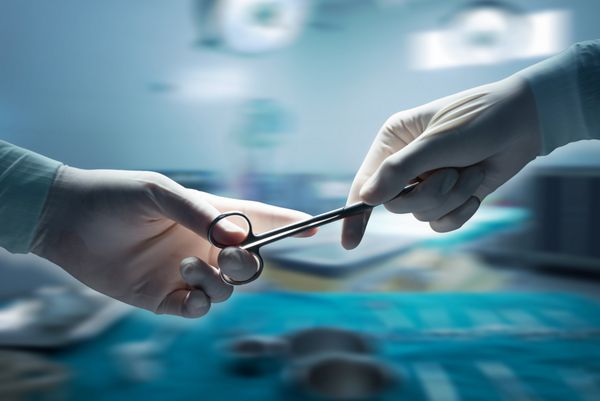 مفهوم مراقبت‌های بهداشتی و پزشکی نمای نزدیک از دست‌های جراح که قیچی جراحی را در دست دارند و تجهیزات جراحی را در دست دارند پس‌زمینه تاری حرکت