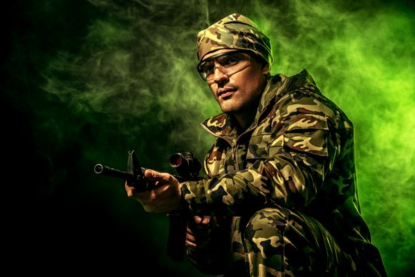 سرباز شجاع در استتار با تفنگ خودکار نظامی