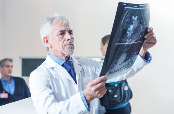 دکتر متخصص در حال تجزیه و تحلیل اسکن اشعه ایکس در بیمارستان
