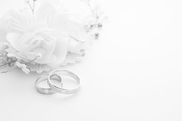حلقه های ازدواج روی کارت عروسی در پس زمینه سفید