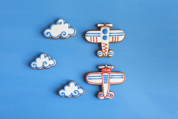 شیرینی زنجفیلی خانگی به شکل هواپیما و ابر روی میز آبی sp برای متن و فوکوس انتخابی