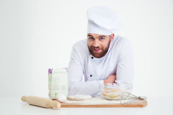 پرتره ای از یک آشپز مرد خندان که در حال پخت است که روی پس زمینه سفید جدا شده است