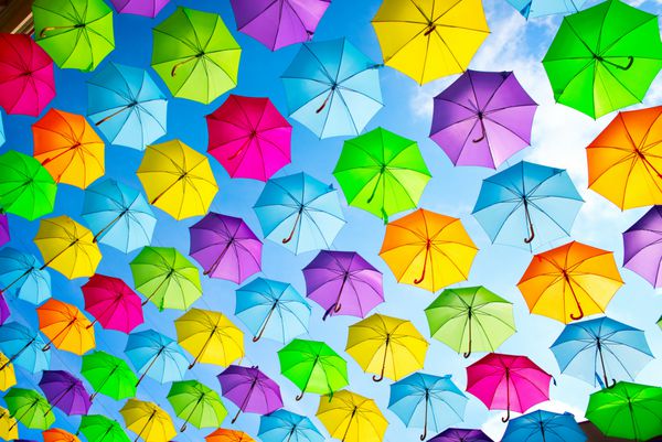 پس زمینه چترهای رنگارنگ چترهای رنگارنگ دکوراسیون خیابان شهری آویزان کردن چترهای رنگارنگ بر فراز آسمان آبی پس زمینه رنگی انتزاعی