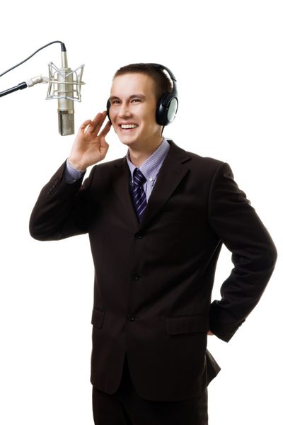 مرد میزبان در ایستگاه رادیویی با میکروفون با کت و شلوار جدا شده روی سفید صحبت می کند