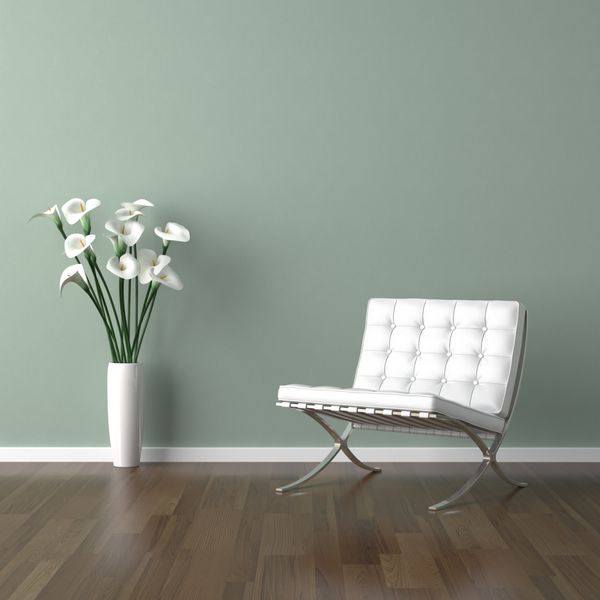 صحنه طراحی داخلی با یک صندلی مدرن سفید و گلدانی از گل زنبق روی دیوار سبز کم رنگ