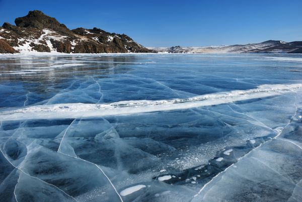 گشت و گذار در یخ سیاه و شفاف با شکاف در دریاچه بایکال در زمستان