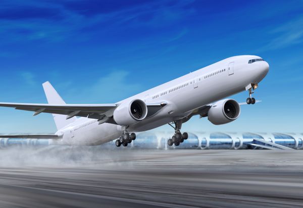 هواپیمای مسافربری سفید دور از فرودگاه در حال فرود است
