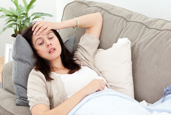 خانمی که در هنگام استراحت روی مبل خانه دمای بدن خود را احساس می کند