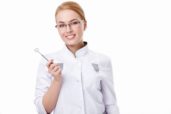یک دندانپزشک جوان با ابزاری روی زمینه سفید