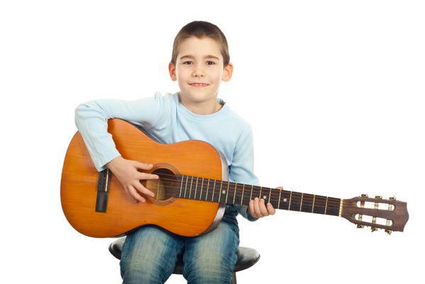 پسر کوچک نشسته روی صندلی و گیتار آکوستیک جدا شده در زمینه سفید